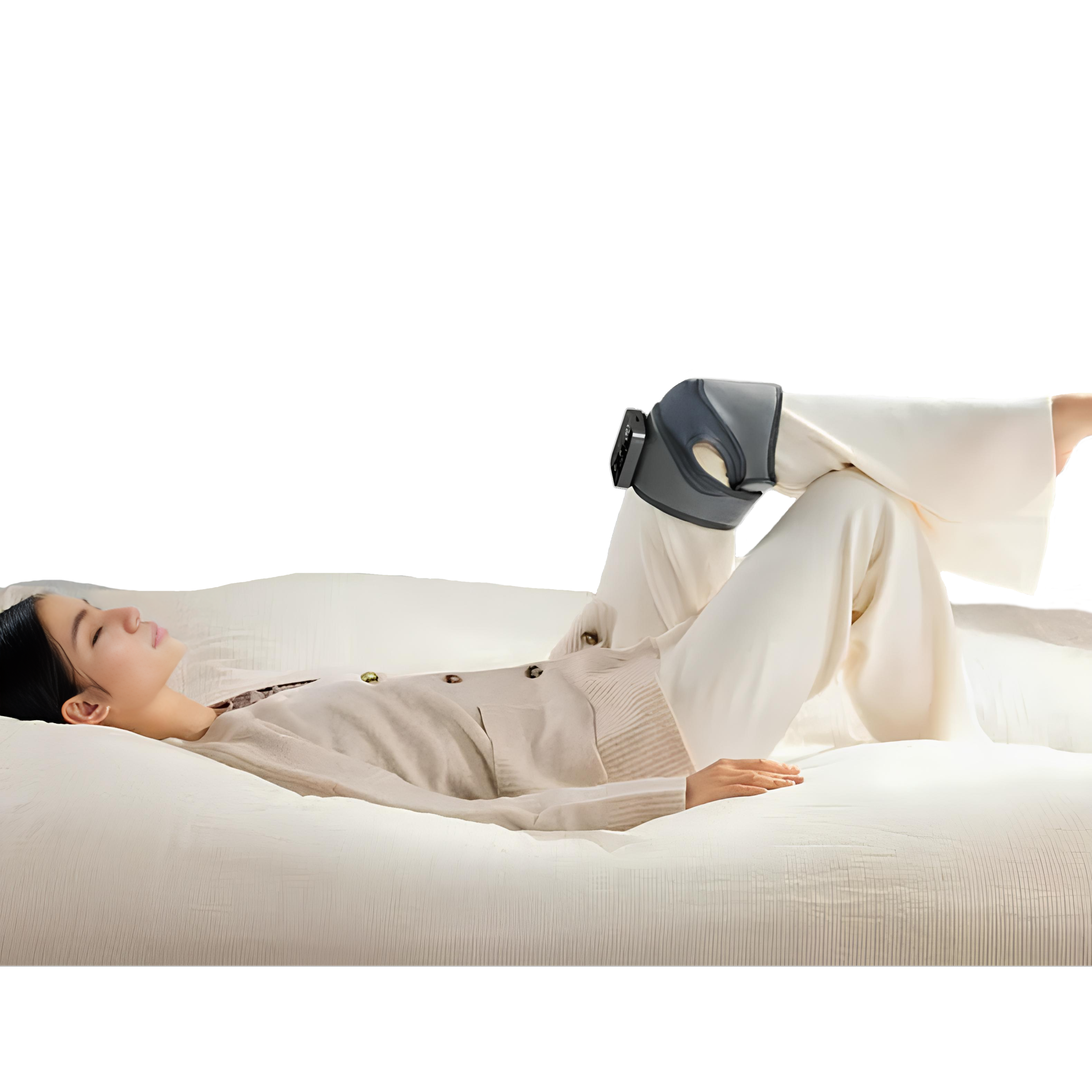 Woman laying on a sofa with a Kneedee heat compression knee massager